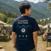 TAKATO RHYTHM Tシャツ 2026 メンズ着用イメージ TAKATO RHYTHM Tシャツを着た男性の後ろ姿と高遠の山並み