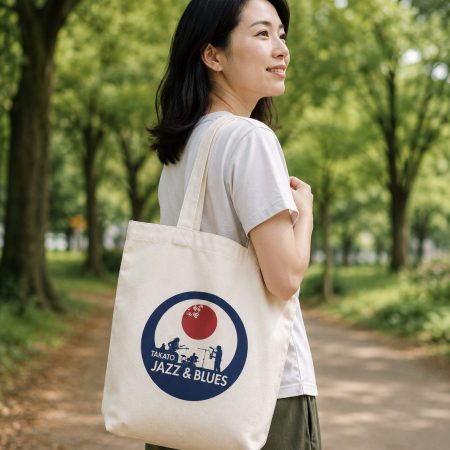 女性がTakato Jazz & Bluesのロゴ入りトートバッグを肩に掛けている様子